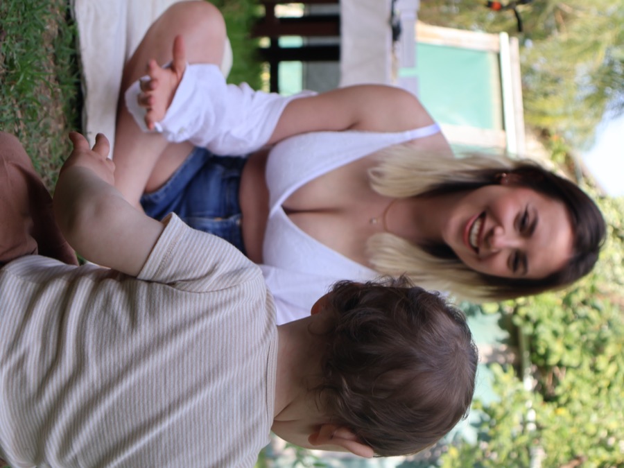 אמא מחייכת עם תינוק לובשת חזיית הנקה לבנה Flow Mama